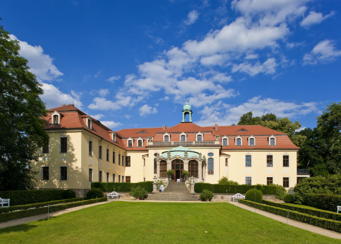 Schloss Proschwitz Außenansicht auf Schloss & den Garten bei blauem, leicht bewölktem Himmel