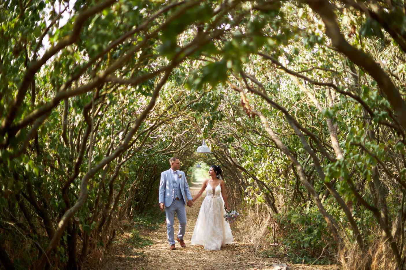 Green Wedding Brautpaar im Laubengang